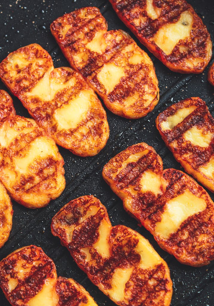 Delicious grilled halloumi cheese slices with golden crust on an iron skillet, perfect for summer dishes.